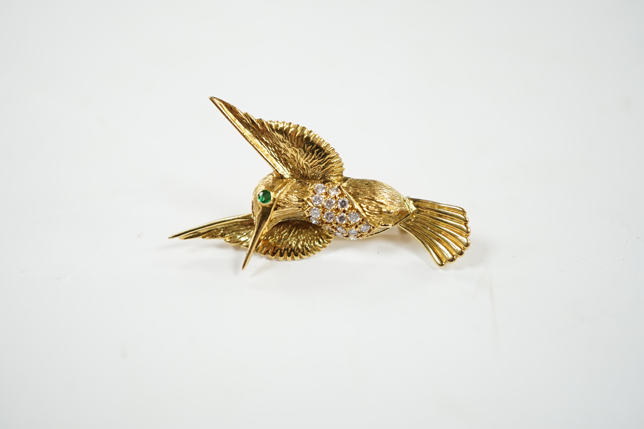 A modern 18ct and diamond cluster set kingfisher brooch, with emerald? set eye, 35mm, gross weight 5.3 grams.